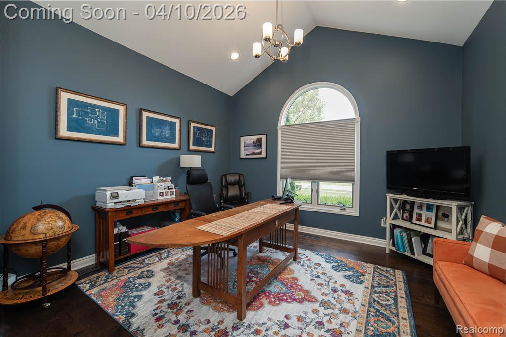 Home office featuring dark wood-style flooring and a chandelier