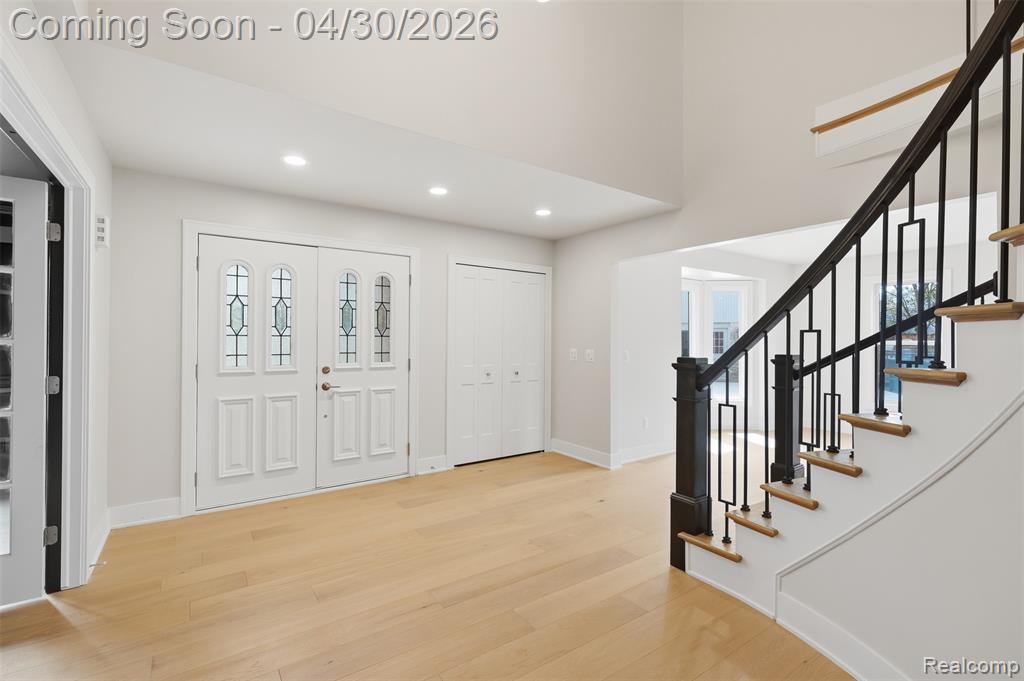 Foyer featuring light wood-style flooring, recessed lighting, a high ceiling, and healthy amount of natural light