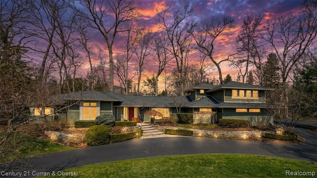 Prairie-style house with curved driveway and a front yard