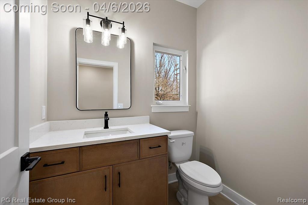 Half bathroom featuring vanity and toilet