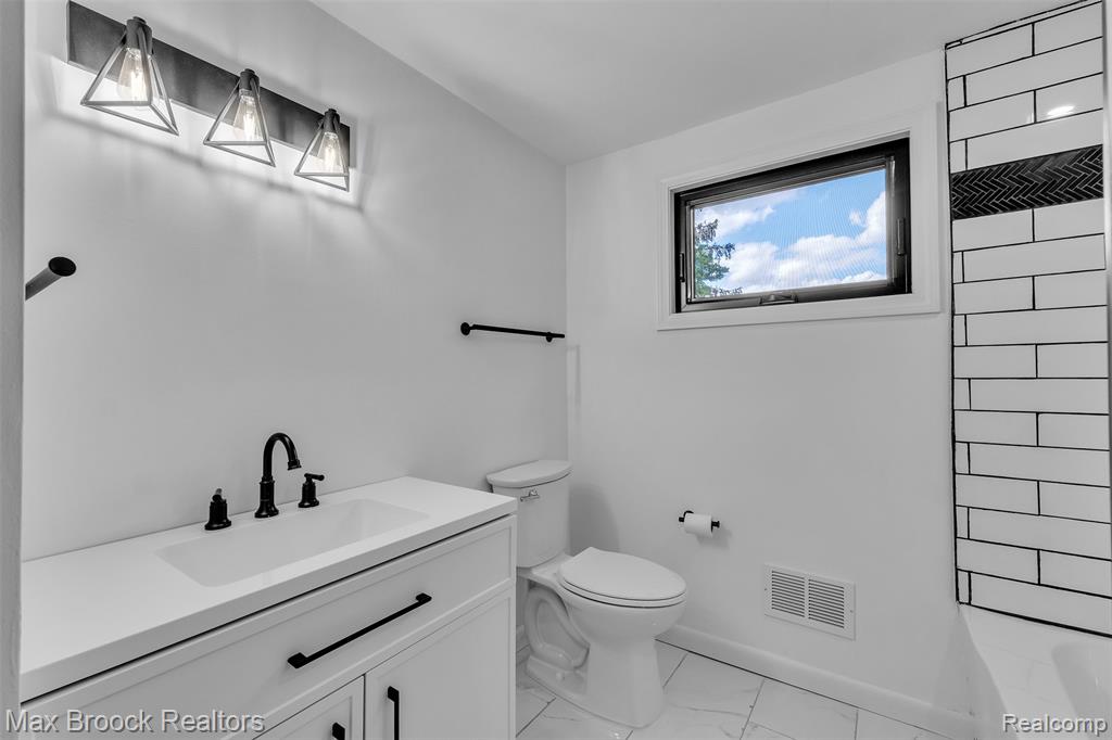 Bathroom featuring vanity and light marble finish flooring