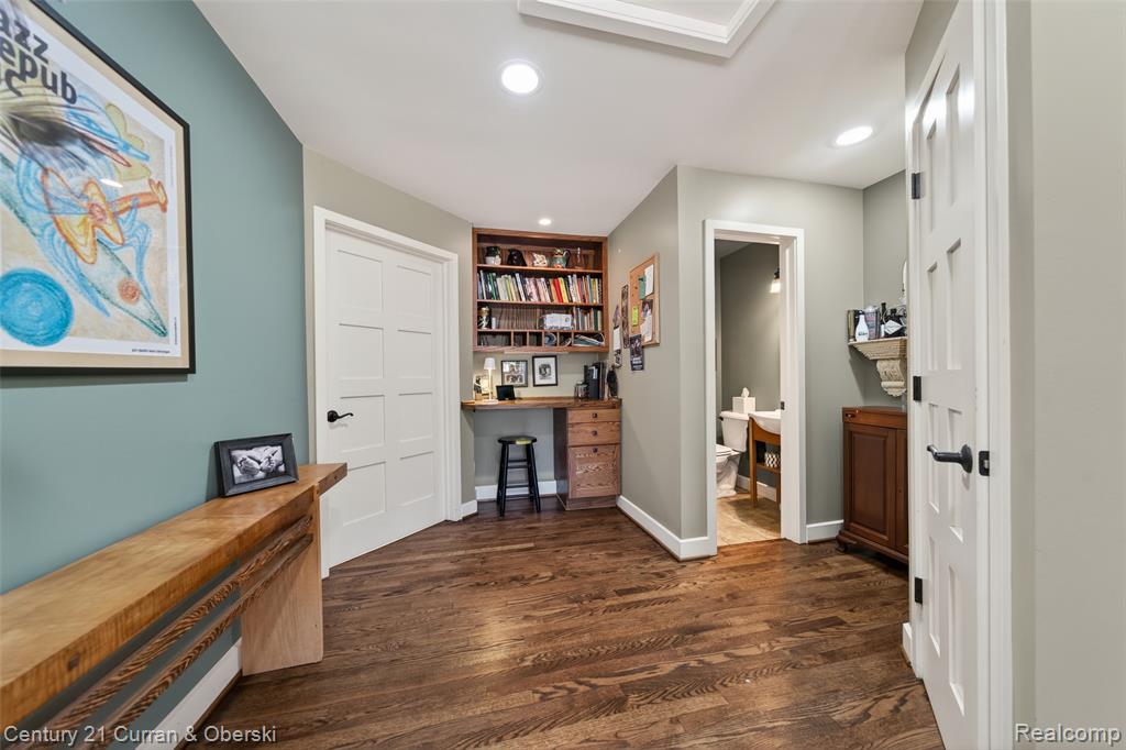 Hallway featuring recessed lighting, dark wood-style floors, and a desk
