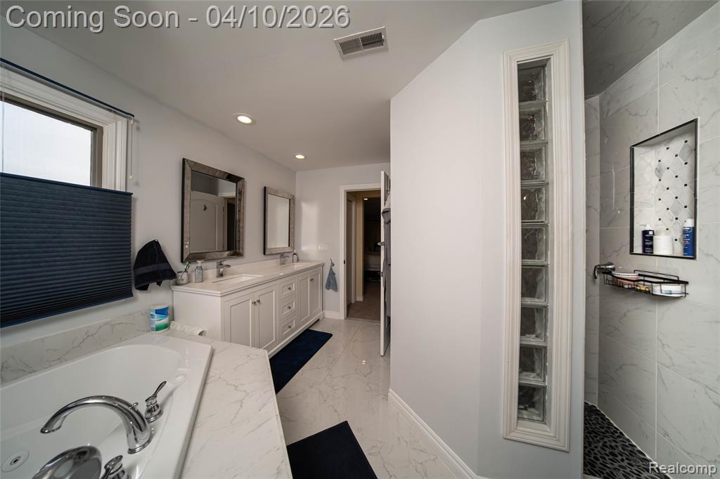 Bathroom featuring double vanity, recessed lighting, light marble finish flooring, a garden tub, and a marble finish shower