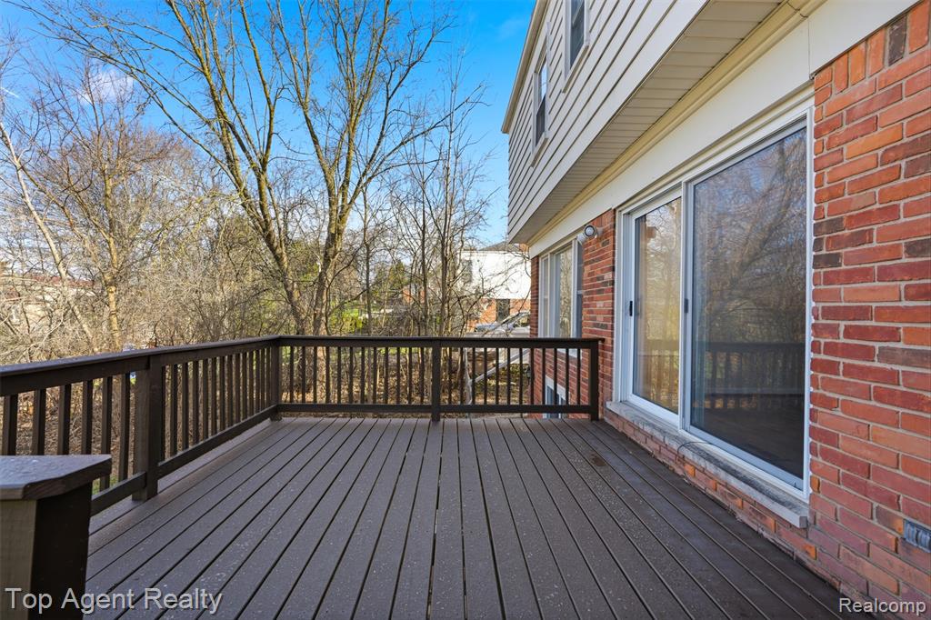 View of front of property featuring brick siding, a garage, driveway, and a front lawn