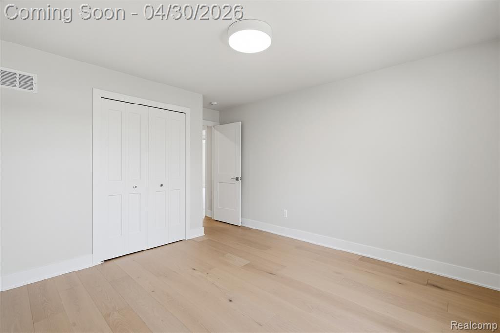 Unfurnished bedroom featuring light wood finished floors and a closet