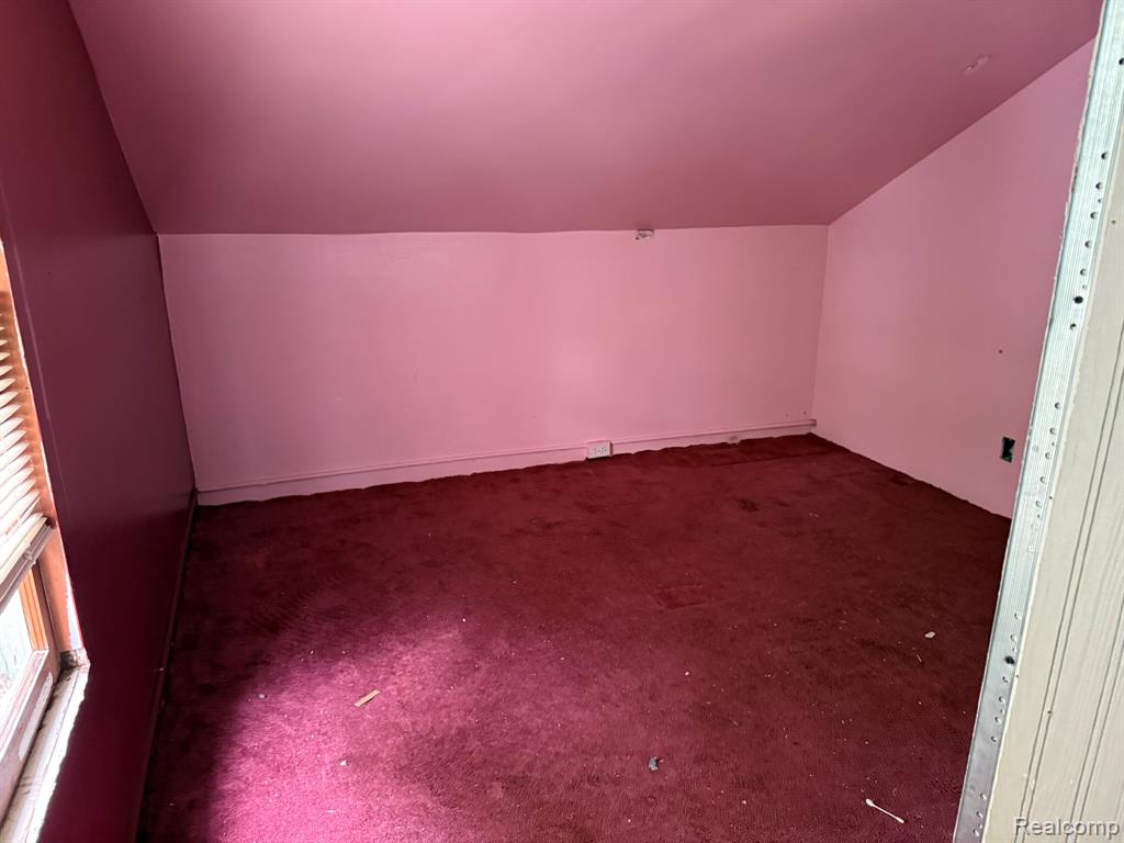 Bonus room featuring carpet flooring and vaulted ceiling