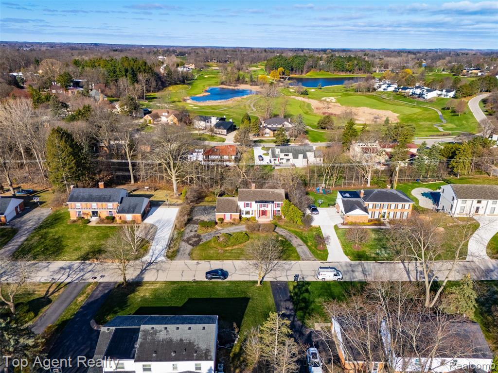 Aerial view of residential area featuring a large body of water and a golf course