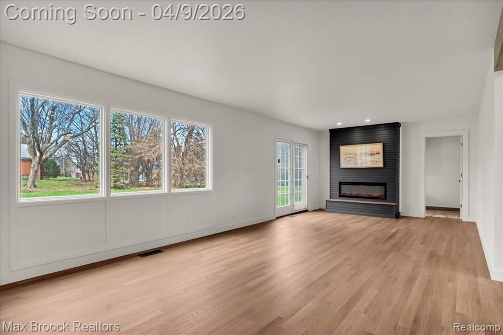 Unfurnished living room featuring light wood-type flooring, a large fireplace, and recessed lighting