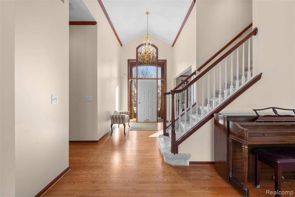 Entryway featuring a chandelier, high vaulted ceiling, and light wood-type flooring
