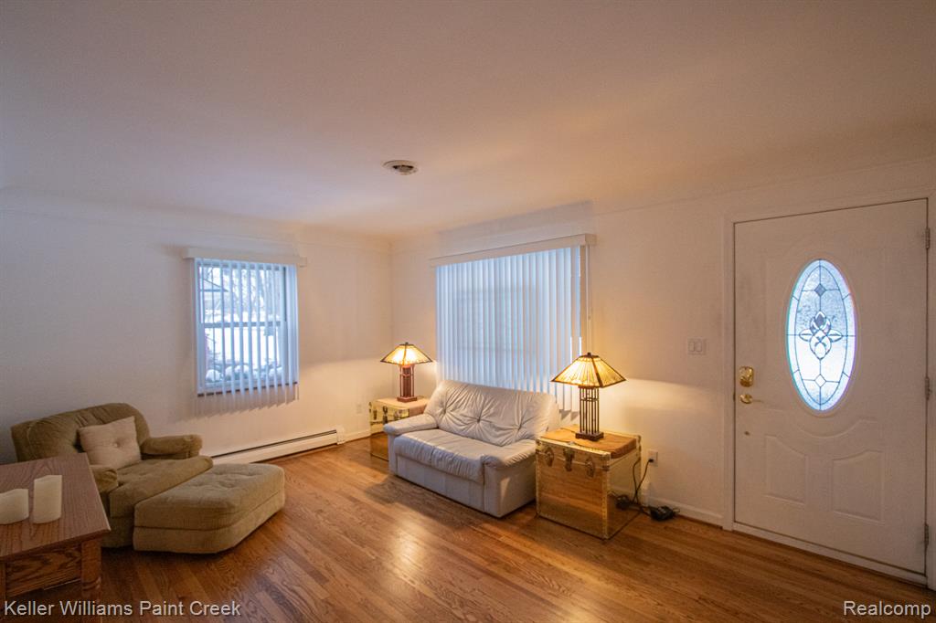 Entrance foyer with a baseboard radiator, wood finished floors, and plenty of natural light