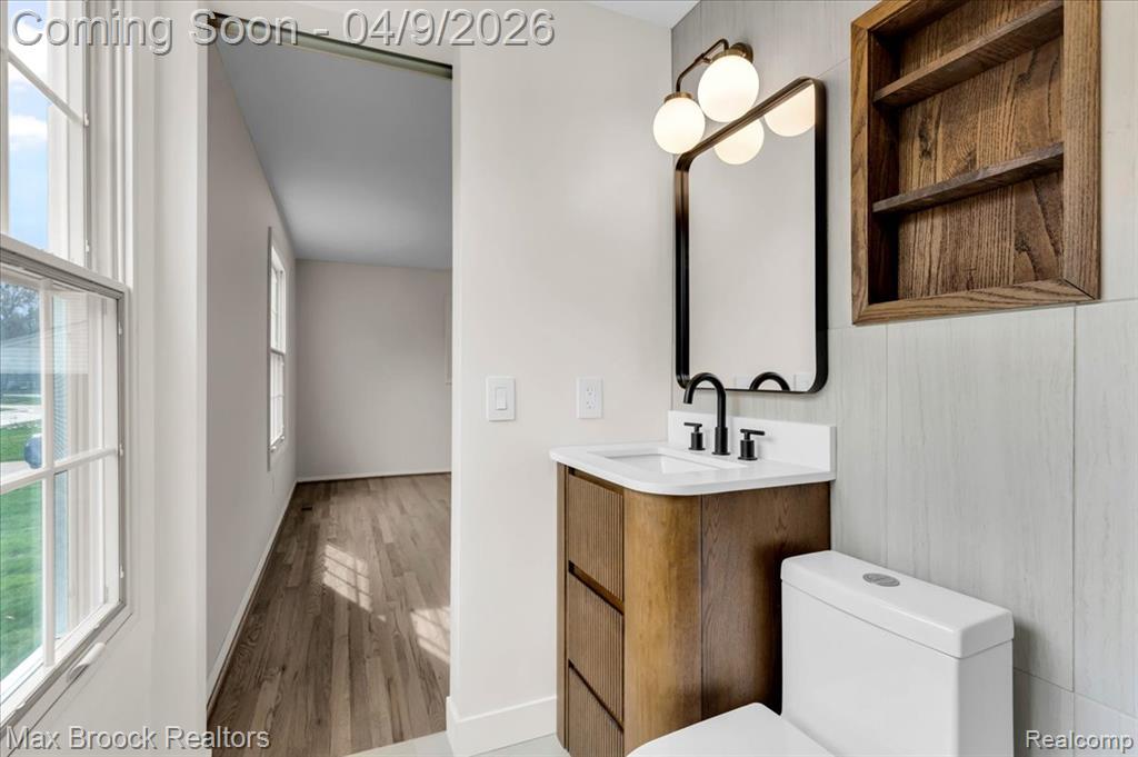 Half bathroom featuring vanity and wood finished floors