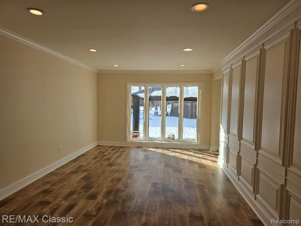 Unfurnished room with crown molding, dark wood-style flooring, and recessed lighting