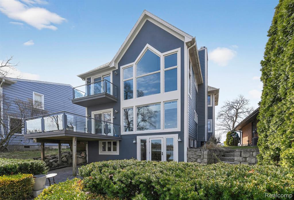 Rear view of house featuring stucco siding and a balcony