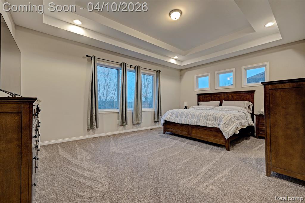 Bedroom with light colored carpet and recessed lighting
