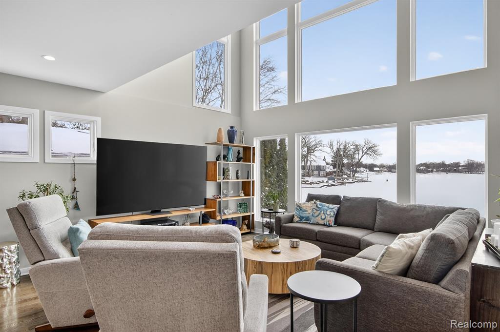 Living area with dark wood-type flooring, stairway, plenty of natural light, and recessed lighting