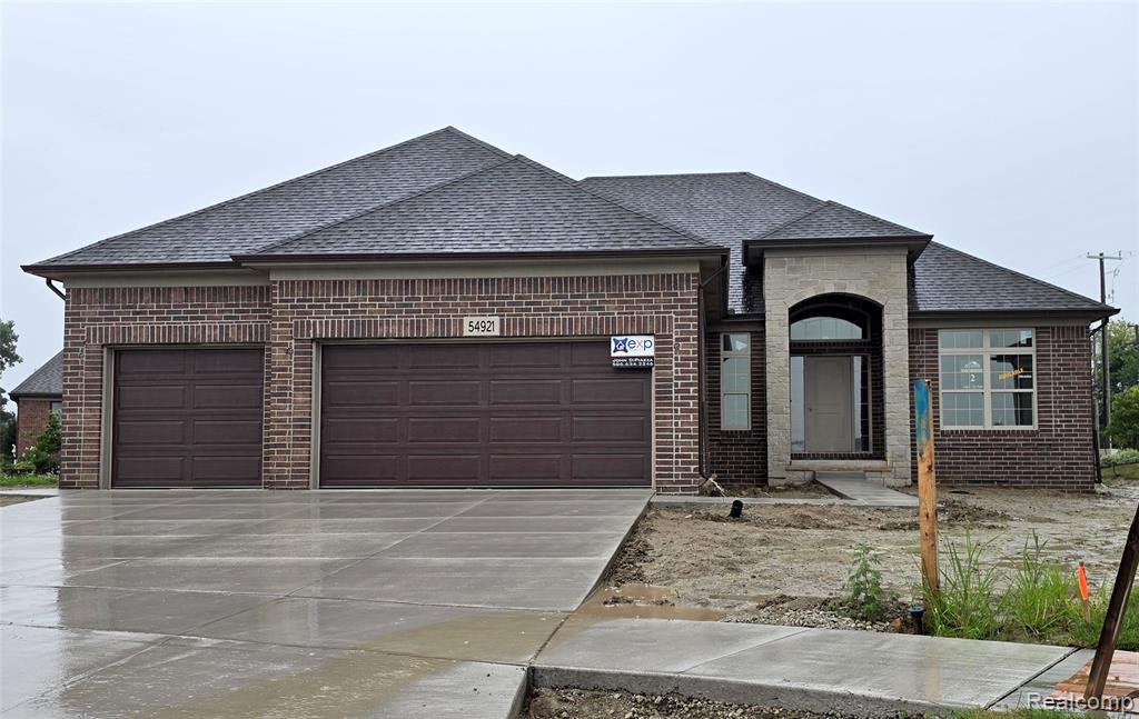 Brick exterior with stone accents and dark shingle roof