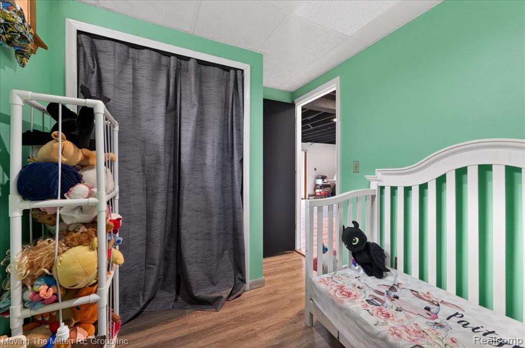 Bedroom featuring wood finished floors and a paneled ceiling