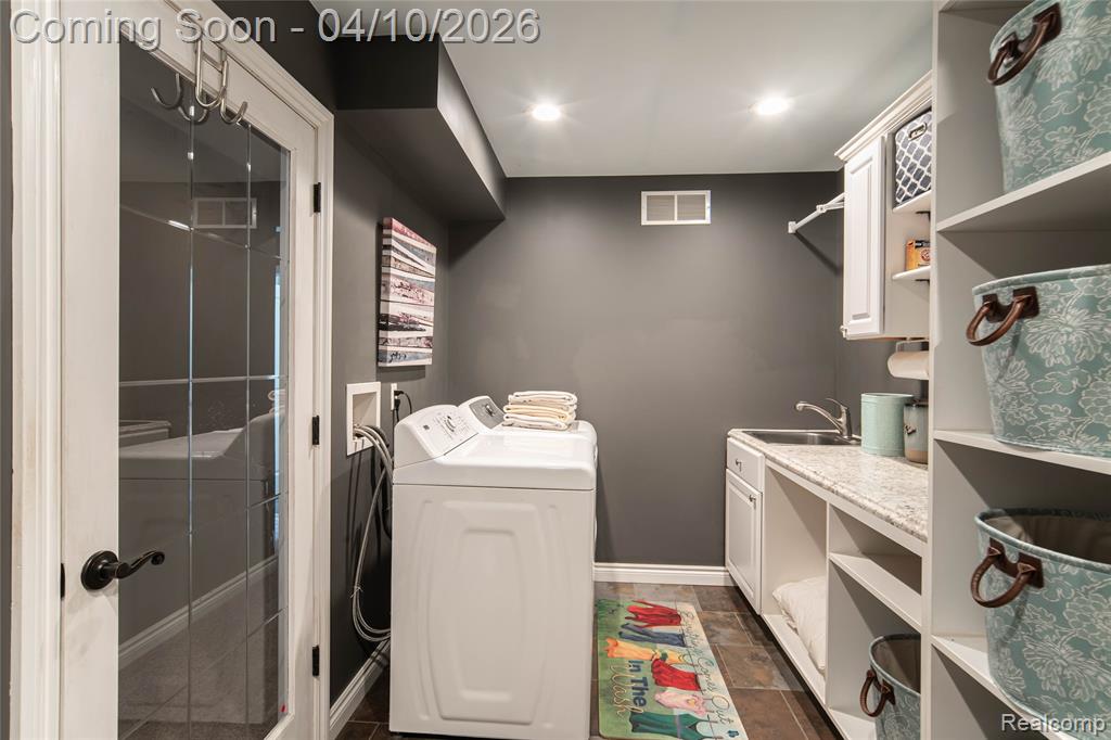 Laundry area featuring washer and dryer, recessed lighting, and cabinet space