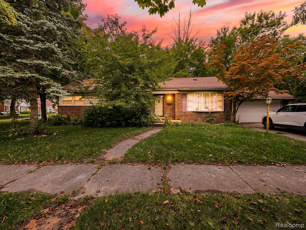 Brick facade, attached garage, mature landscaping, front walkway, and covered entry