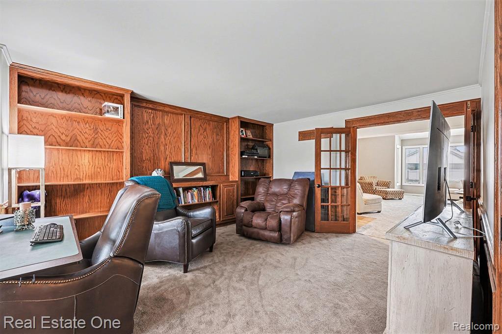 Office area with french doors, light colored carpet, and crown molding