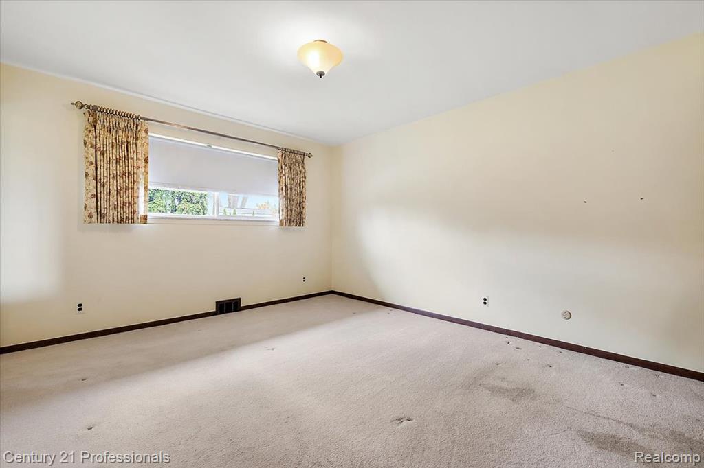 Spare room with carpet and baseboards