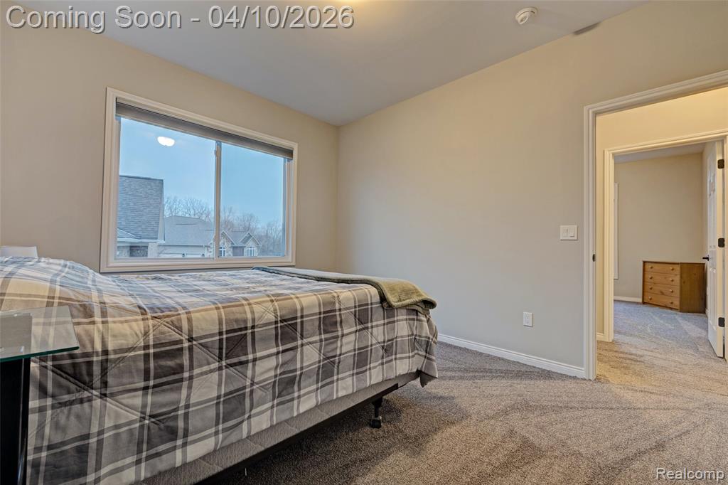 Bedroom with light colored carpet and baseboards