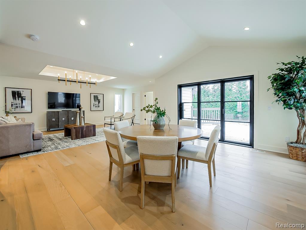 Dining room featuring light wood-type flooring, vaulted ceiling, and recessed lighting