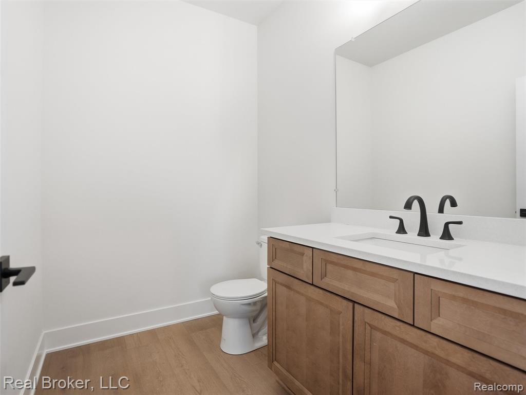 Half bathroom with vanity and light wood-style floors