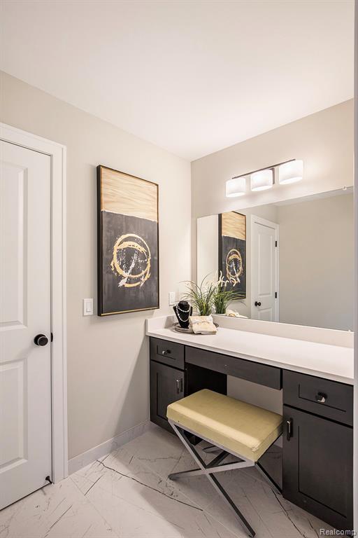 Bathroom featuring light marble finish floors and vanity