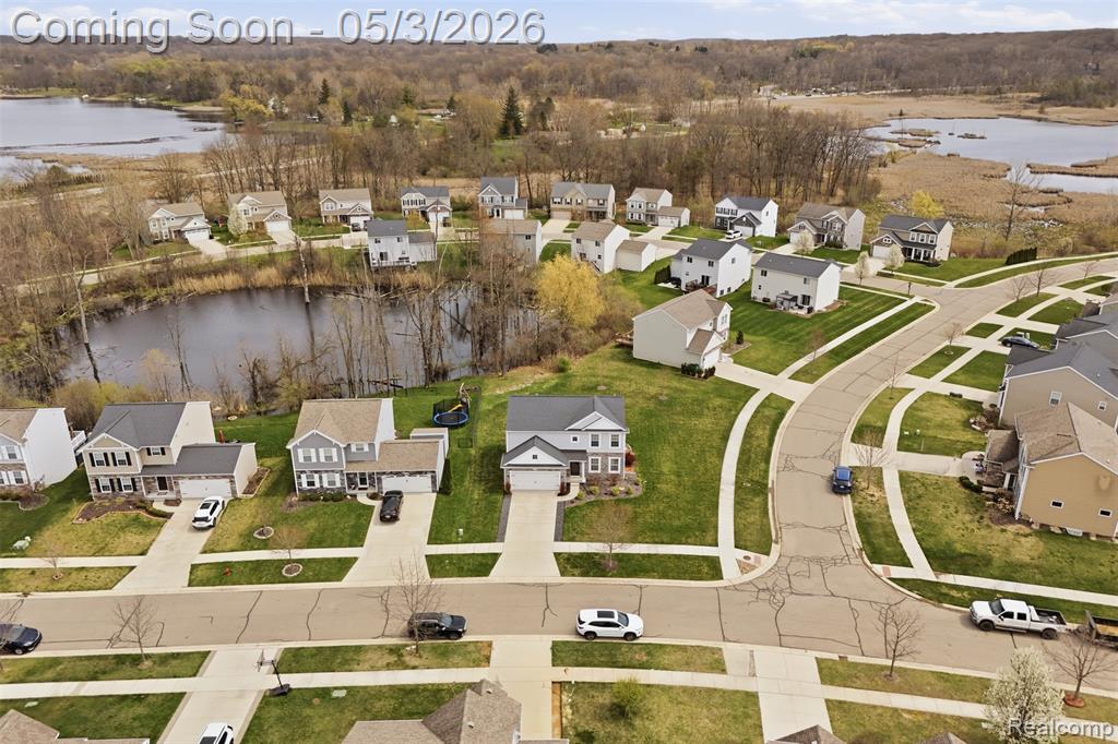 Aerial perspective of suburban area featuring a nearby body of water
