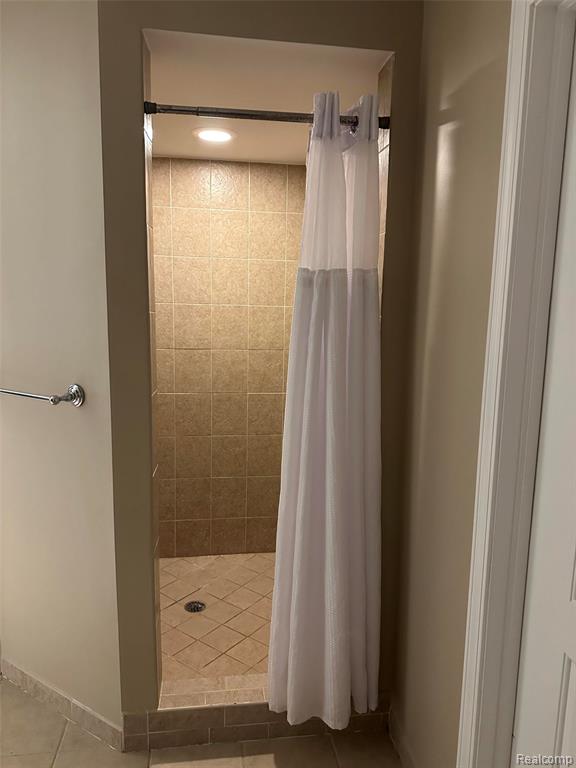 Bathroom with a stall shower, light tile patterned floors, and recessed lighting