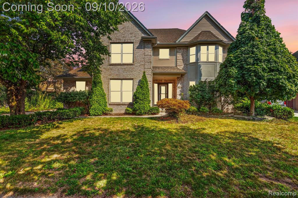 Elegant two-story residence featuring a brick and stone exterior with ivy-covered architectural details