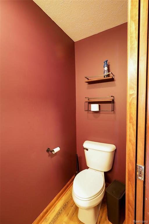 Bathroom with light wood finished floors and a textured ceiling