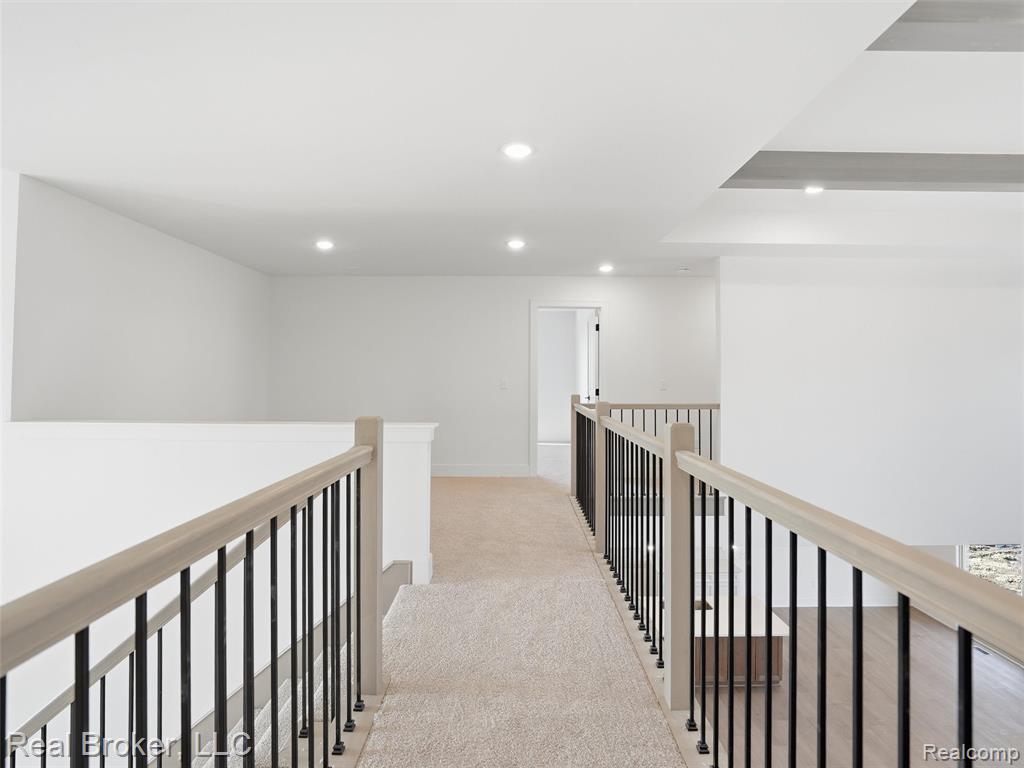 Hallway with light carpet and recessed lighting