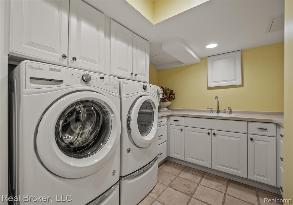 Laundry room with washer and dryer, cabinet space, and recessed lighting