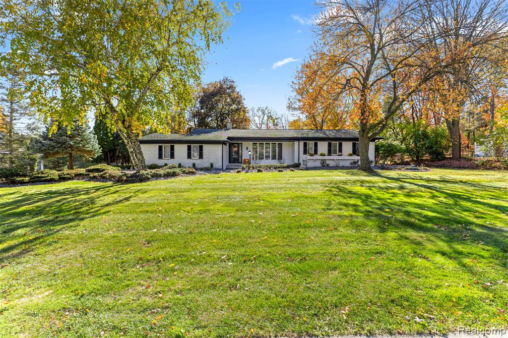 Photo for 38067 Southfarm Lane, Northville, MI 48167 - listing #20251054149 View of front of property featuring a front yard, brick siding, and a chimney