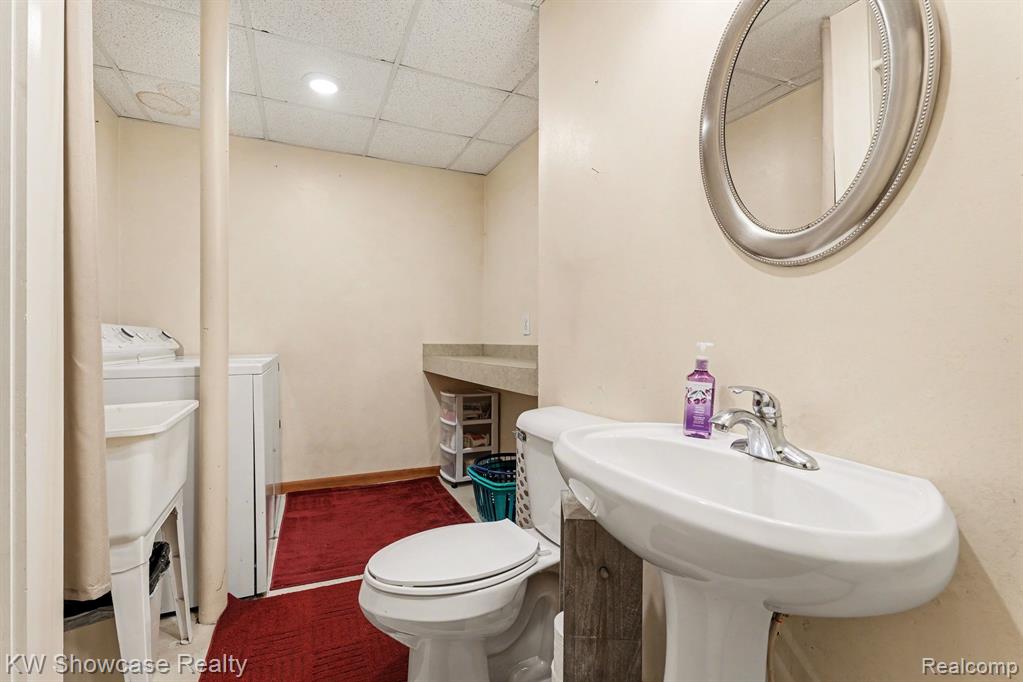 Bathroom featuring a paneled ceiling and washing machine and dryer