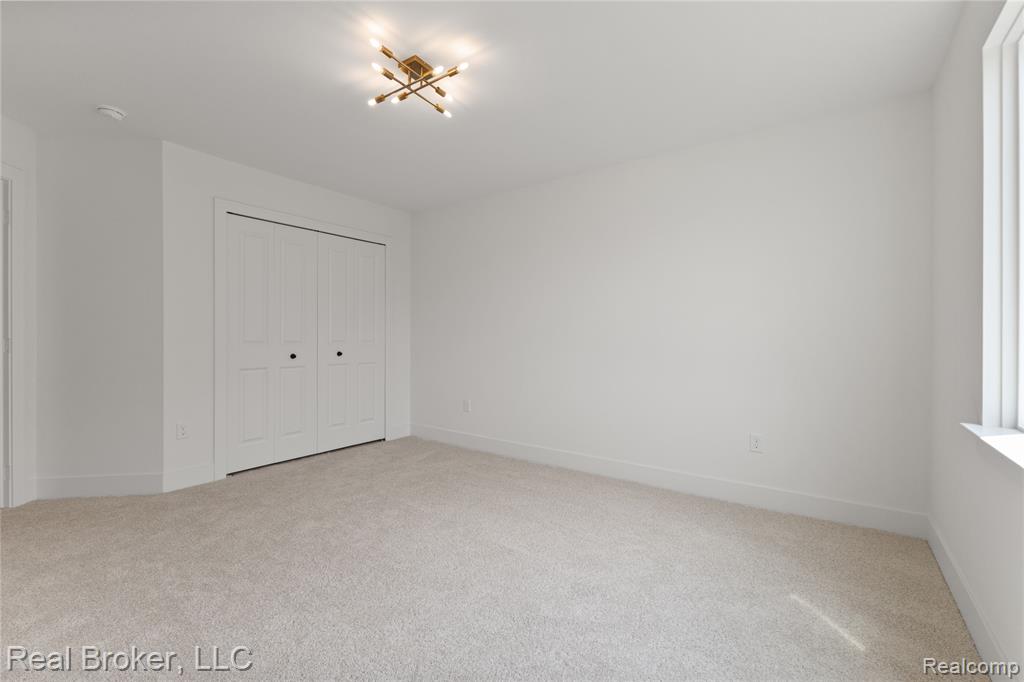 Unfurnished bedroom with light carpet and a closet