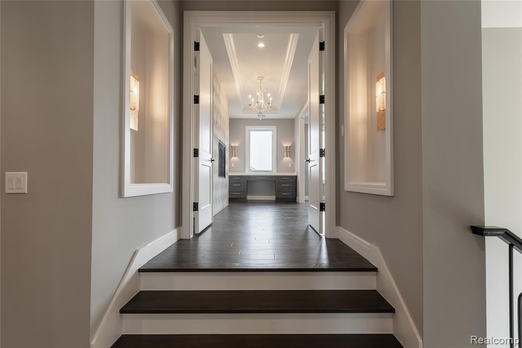 Entrance foyer with dark wood-style floors and suspended lighting