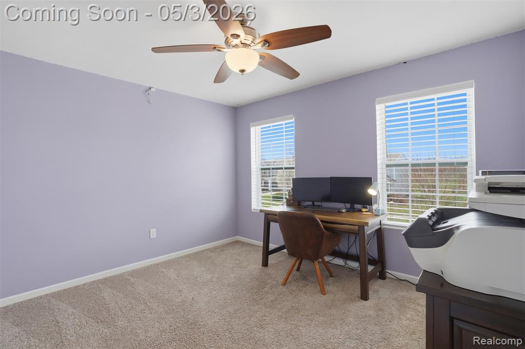 Bedroom used a office space featuring light carpet and ceiling fan