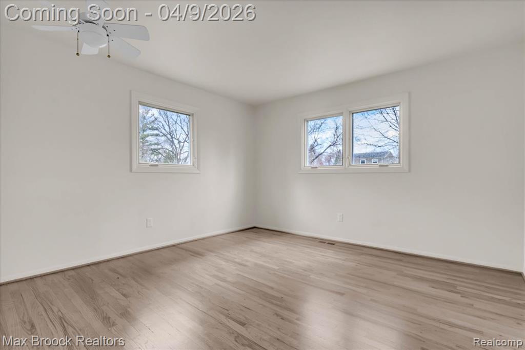 Empty room with light wood-style flooring and ceiling fan