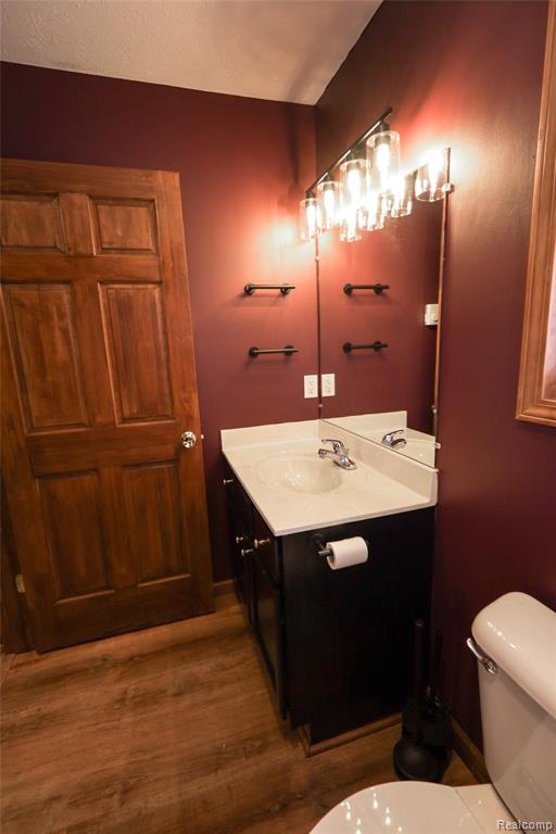 Half bath featuring dark wood-style flooring and vanity