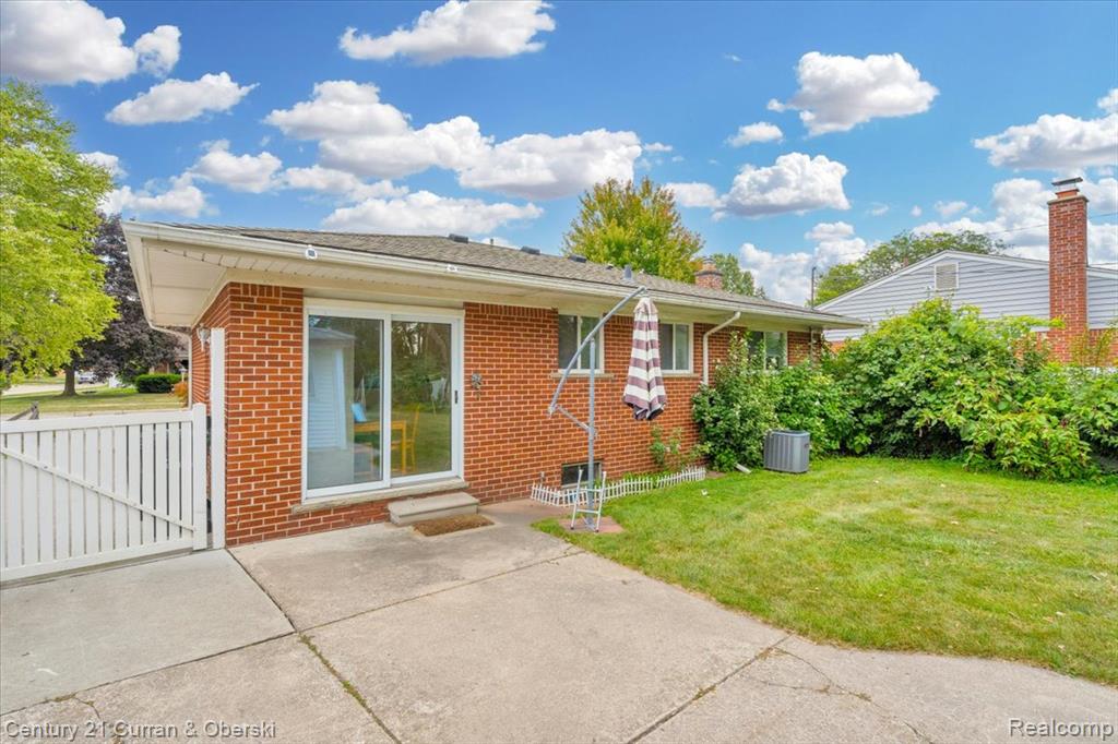 Rear view of house featuring brick siding, a patio area