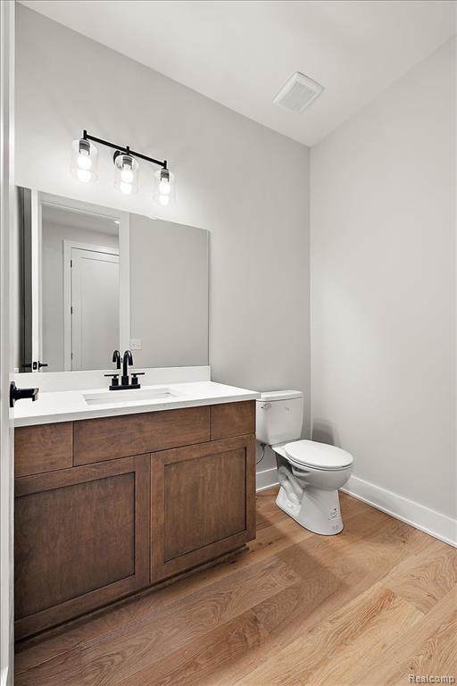 Half bath featuring vanity and light wood finished floors