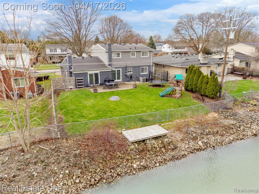 Back of property with a patio, a playground, a fenced backyard, and a residential view