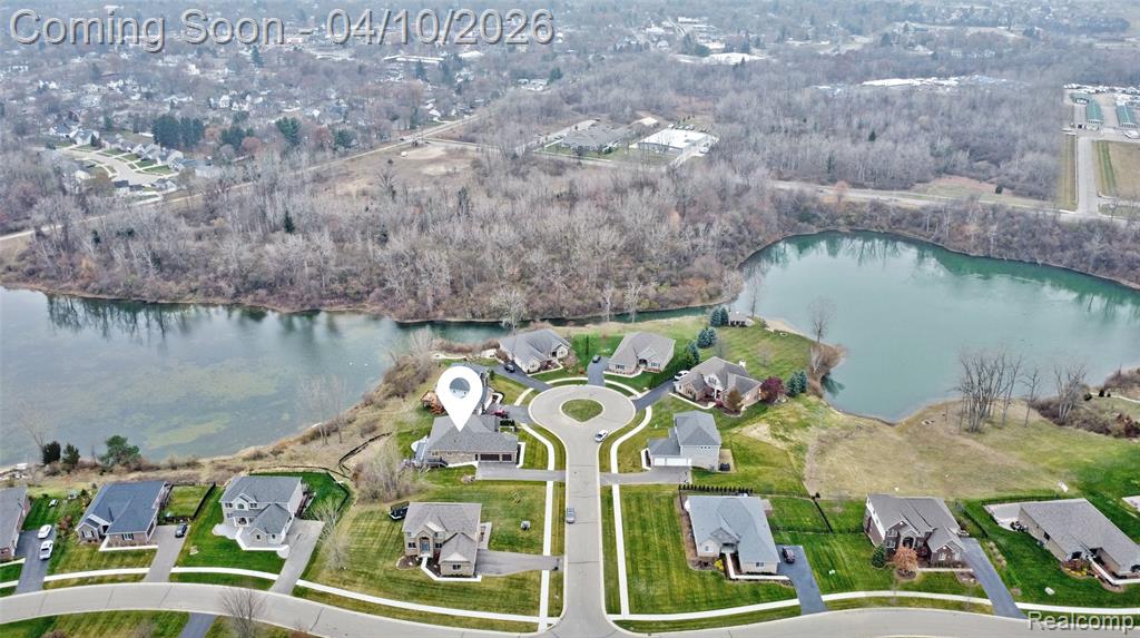 Aerial view of property and surrounding area featuring nearby suburban area