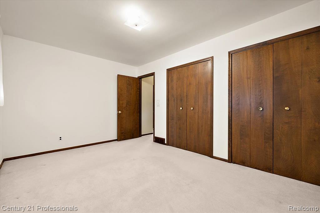 Unfurnished bedroom with two closets and carpet floors