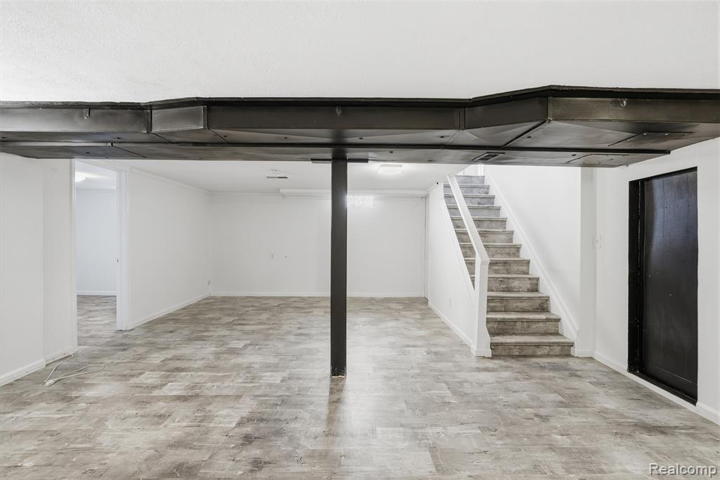 Finished below grade area featuring stairway and light wood-type flooring