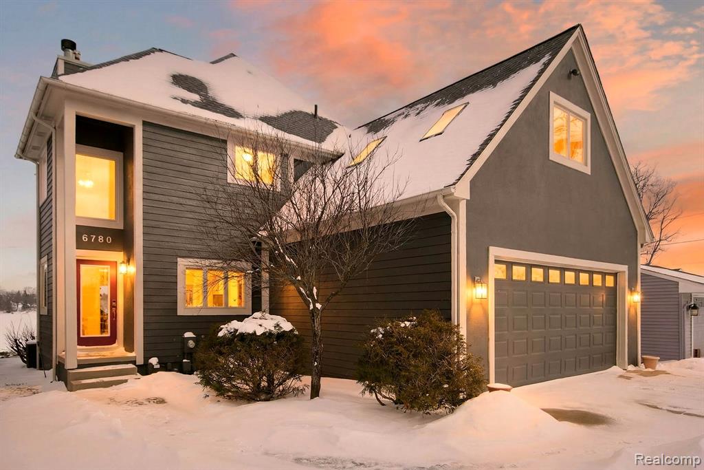 View of front of home with driveway, a garage, a shingled roof, and a front lawn