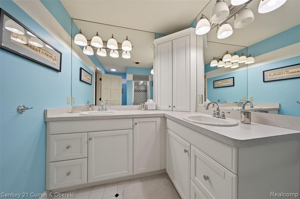 Full bathroom with vanity, a stall shower, and light tile patterned floors